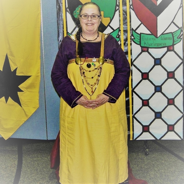 Jennie, This has a purple underdress with yellow silk stitching on neck, sleeves and hem.  The apron has han...
