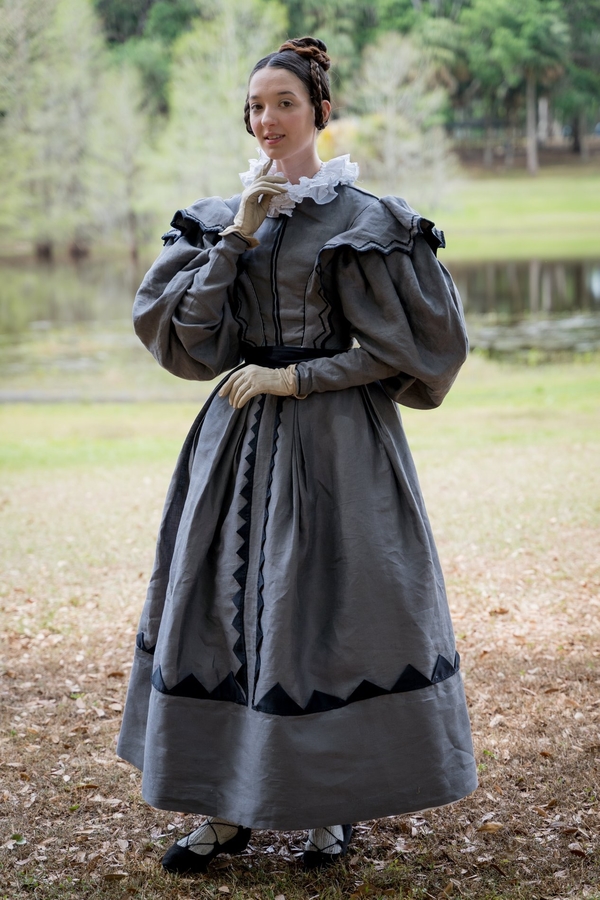 Brigitte, This 1830’s grey “grisette” dress is made with mainly grey linen and black cotton sateen. The dress...
