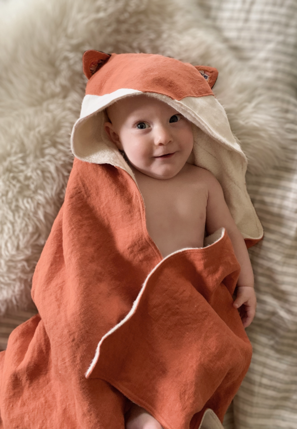 Celeste, A hooded baby towel with fox ears made in orange heavy weight linen with white appliqué on the hood...