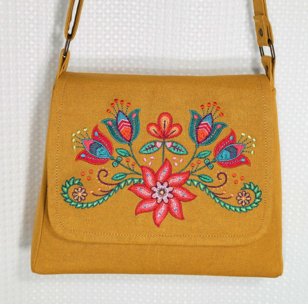 Linda, This sleek amber handbag features colorful Peruvian style embroidery in coordinating bright colors....
