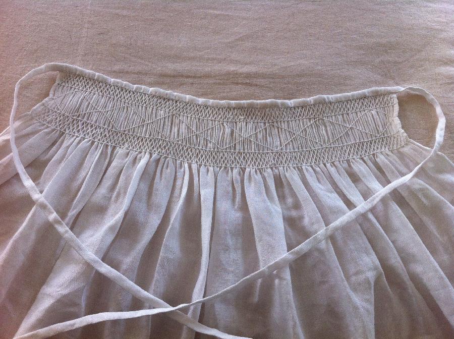 Christine, This linen apron is all hand sewn and hand smocked. Whipped, horizontal and oblique smocking stitche...
