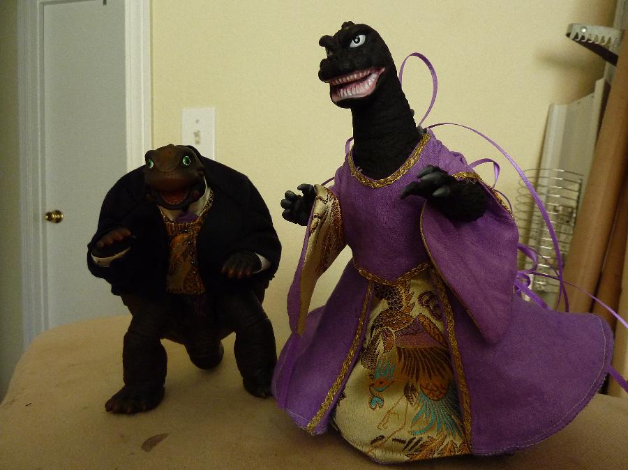 Susi, Groomera and Bridezilla cake toppers are garbed in miniature matching replicas of the actual Bri...