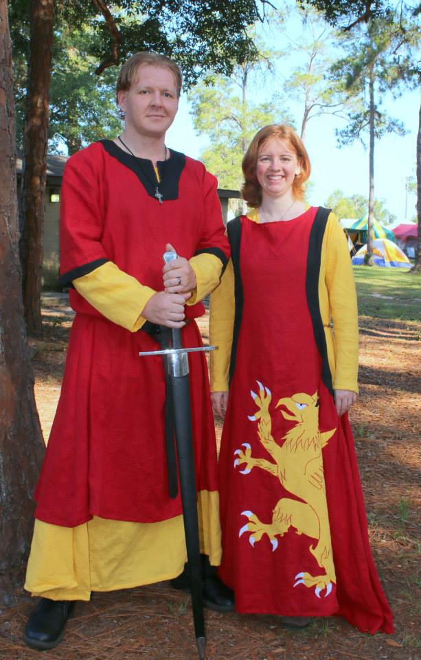 Crissy, 12th century Germanic paired tunics for him and a 13th century sideless surcoat with griffin appliqu...