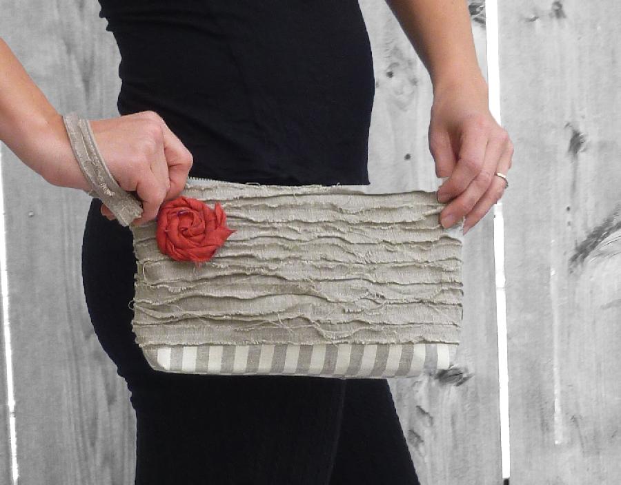 Devon, A strapped clutch made from two medium weight linens and adorned with a linen rosette. The upper por...