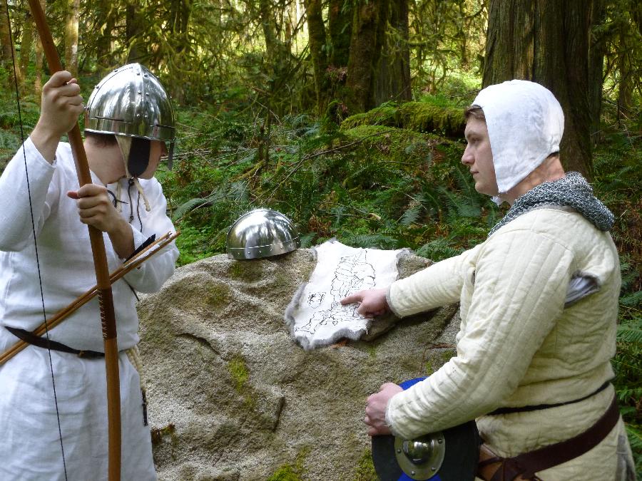 C storme, Reviewing the map.

Gambeson, under tunic, braies (not visible), arming cap (not visible), and lin...