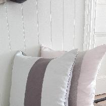 Feather filled large, lounging pillows in a combination of soft pink and mix natural linen and d...