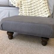 Interior design category: A comfy, roomy footstool covered with the IL019 in Asphalt.
