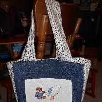 Baby bag done in denim with pockets, magnetic closure, and cross stitch applique. The cross stit...